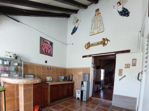 a kitchen with a counter and a refrigerator at Hostal Ruinas de San Sebastián in León