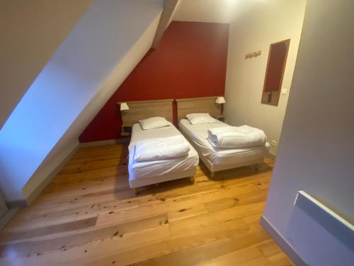 two beds in a small room with a staircase at Appartement en duplex pour 8 personnes in Arreau