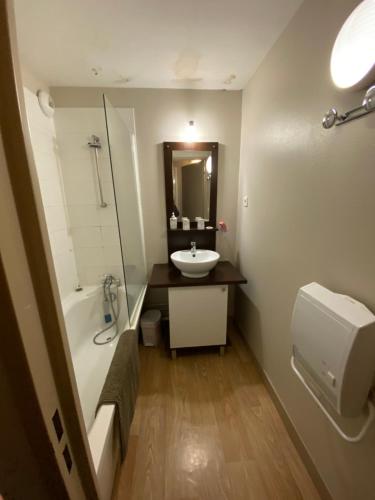 a bathroom with a sink and a tub and a toilet at Appartement en duplex pour 8 personnes in Arreau