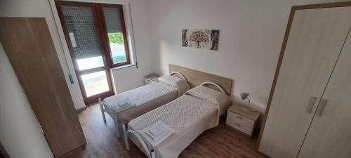2 camas de hospital en una habitación con ventana en Villa Eufrosine en Palermo