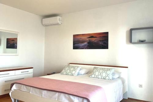a bedroom with a bed and a tv on the wall at At Jenny in Omiš