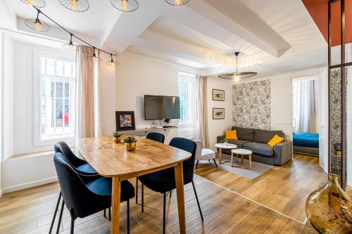 une salle à manger et un salon avec une table et des chaises dans l'établissement Plein centre avec 