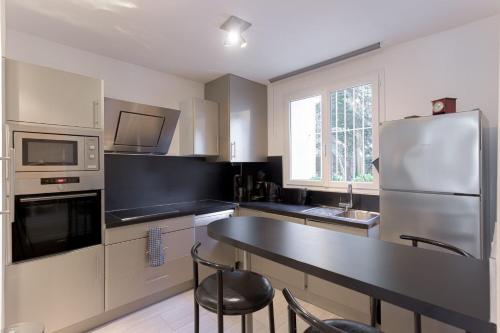 Il comprend une cuisine équipée d'un réfrigérateur, d'une table et de chaises. dans l'établissement Duplex Saint-henry by Halldis, à Cannes