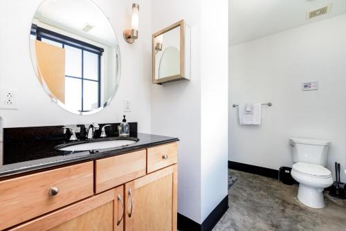 a bathroom with a sink and a mirror and a toilet at CozySuites Spacious 2BR penthouse w Skyline view in Saint Louis