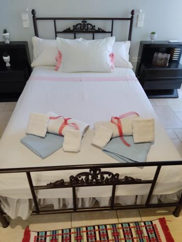 a large white bed with towels and pillows on it at Πέτρινο στη θάλασσα in Nafpaktos