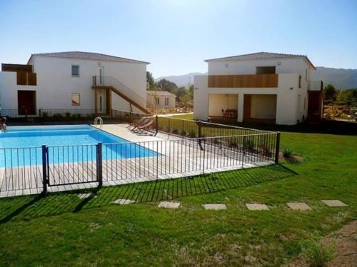 une maison avec une piscine devant une maison dans l'établissement Appartement 2/4 pers, piscine, proche mer, Lecci, à Lecci