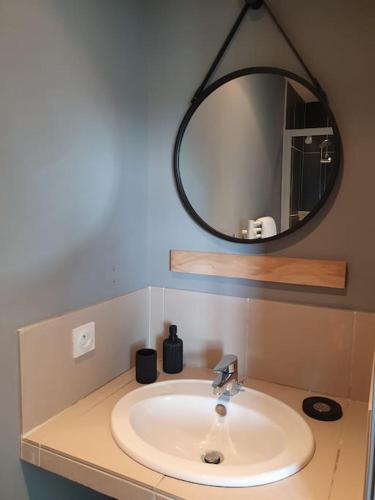 une salle de bain avec un lavabo et un miroir dans l'établissement Appartement 2/4 pers, piscine, proche mer, Lecci, à Lecci