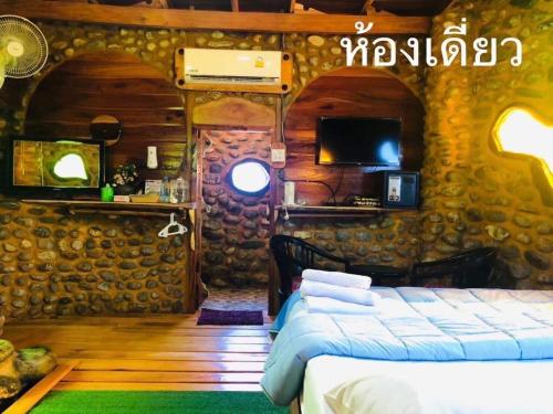 um quarto com uma cama e uma televisão numa casa em ลีลา โฮมสเตย์ Leela Homestay em Ban Tha Phae