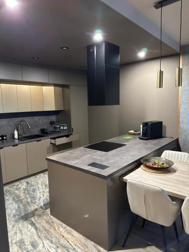 a kitchen with a counter and a table with chairs at GOLD Apartment Centrum garaż in Gliwice
