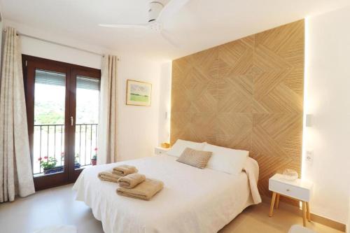 Un dormitorio con una cama blanca con toallas. en Antana, en Frigiliana