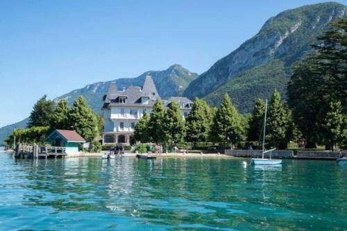 une maison au bord d'un plan d'eau dans l'établissement Bel appartement au calme à 5 minutes du village, à Menthon-Saint-Bernard