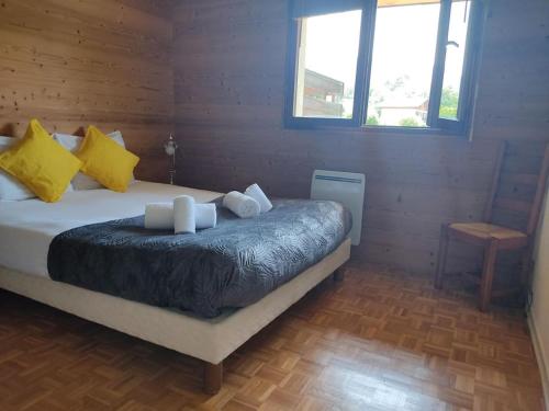 - une chambre avec un lit doté d'oreillers jaunes et blancs dans l'établissement Bel appartement au calme à 5 minutes du village, à Menthon-Saint-Bernard