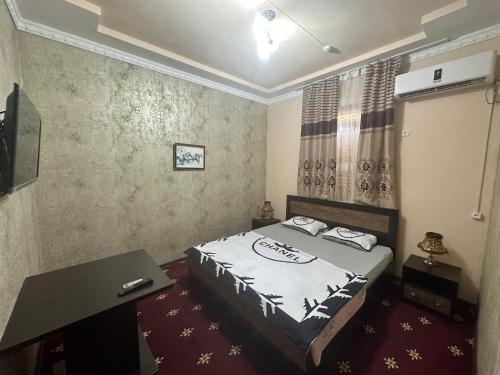 a bedroom with a bed and a desk in it at Mumtoz Plaza in Bukhara