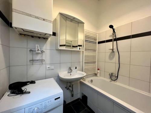 ein weißes Badezimmer mit einem Waschbecken und einer Badewanne in der Unterkunft little cozy residence - enjoy Viennas summer season in Wien