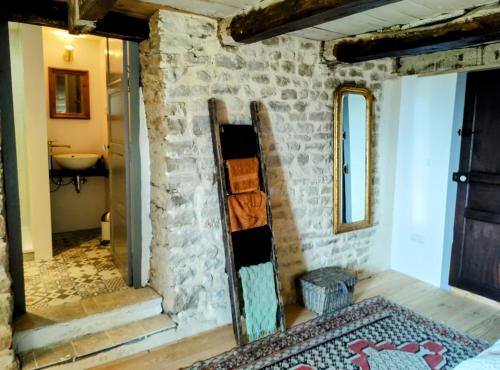 a room with a stone wall and a mirror at Chateau d 'Impasse in Laferté-sur-Amance