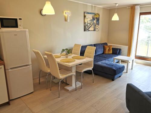 uma sala de estar com uma mesa e um sofá azul em Apart Harmony - Apartamenty Przy Zatoce em Puck