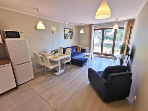 uma sala de estar com um sofá e uma mesa com cadeiras em Apart Harmony - Apartamenty Przy Zatoce em Puck