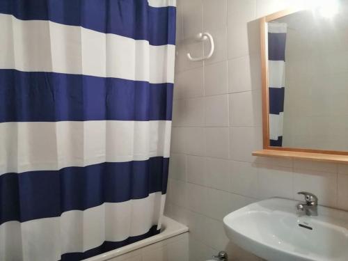 a bathroom with a blue and white shower curtain at Planta baja tranquila Besiberri 11 in Pla de l'Ermita