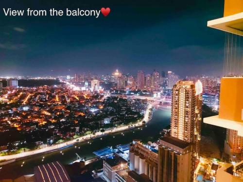 a view from the balcony of a city at night at Fully-Airconditioned 2-BR Unit near BGC in Manila
