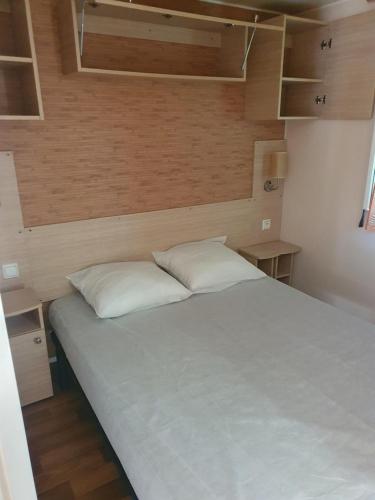 une chambre avec un grand lit blanc dans une pièce dans l'établissement Mobil-home ( dépaysement total à 40 km de paris ), à Saint-Chéron
