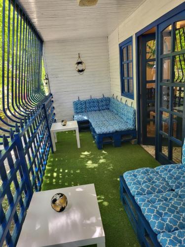 a patio with blue chairs and a table and a couch at Silver Beach Apartman in Vásárosnamény