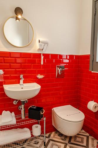 a red bathroom with a toilet and a sink at Rooms AL-Zabut in Sambuca di Sicilia