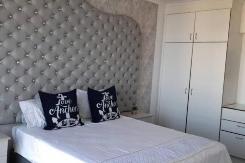 a bedroom with a large bed with a large headboard at Oceanic eleven in Durban