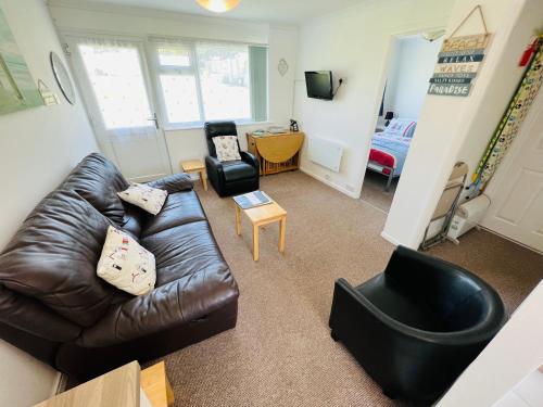 a living room with a leather couch and a chair at 2 Bedroom Chalet SB113, Sandown Bay, Isle of Wight in Brading