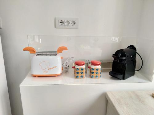 ein Regal mit einem Toaster und drei Tassen drauf. in der Unterkunft casArancia in Rom