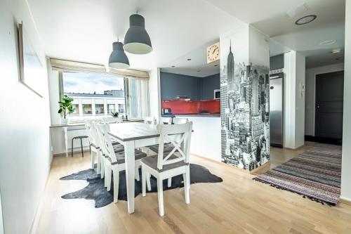 a kitchen and dining room with a white table and chairs at Beautiful penthouse in the center of Helsinki in Helsinki