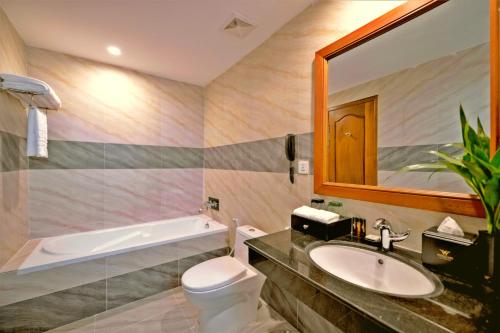 a bathroom with a sink and a toilet and a mirror at Poulo Wai Hotel & Apartment in Phnom Penh