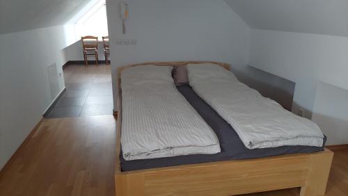 a bed with a wooden frame in a room at Apartma Samo in Kranj