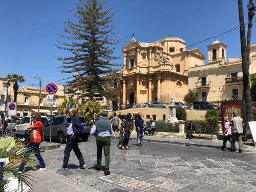 a group of people walking down a city street at Tannur Del Carmine in Noto