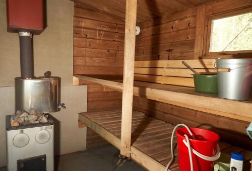 d'une cuisine avec une cuisinière et des murs en bois. dans l'établissement Rantasaunallinen yksiö, à Virrat