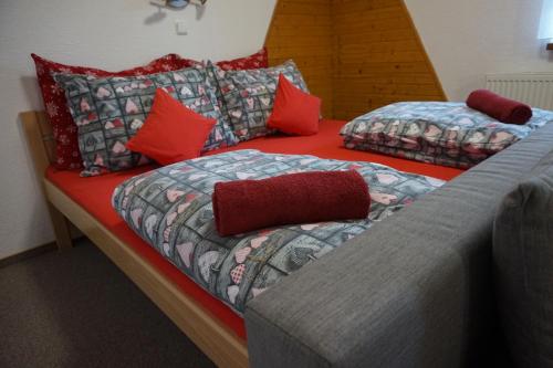 two beds in a room with red pillows at Penzion a restaurace Na Hvězdě in Malá Morávka