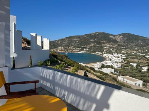 a balcony with a bench and a view of a bay at Venikouas Hotel in Platis Yialos Sifnos
