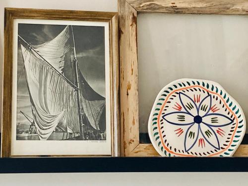 deux photographies encadrées et une assiette sur une étagère dans l'établissement Chambre proche Elysée, à Paris