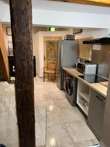 Il comprend une cuisine équipée d'un réfrigérateur et d'une cuisinière. four supérieur dans l'établissement APPARTEMENT CAROMB proche Mont VENTOUX avec clim, à Caromb