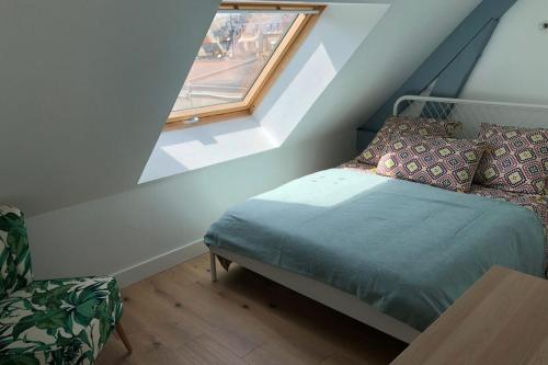 a small bedroom with a bed and a window at Place 6 nice apartment in the heart of Arromanches in Arromanches-les-Bains