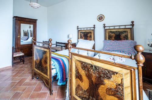 a bedroom with two beds and a mirror at La casa in piazza in Panicale