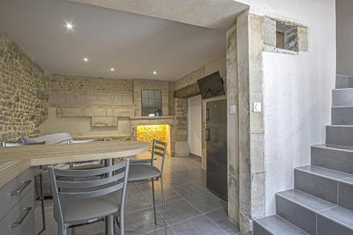 - une cuisine et une salle à manger avec une table et des chaises dans l'établissement La cour des teinturiers, à Bayeux