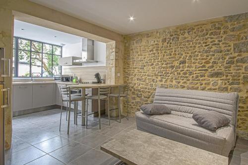 a living room with a couch and a kitchen at La cour des teinturiers in Bayeux