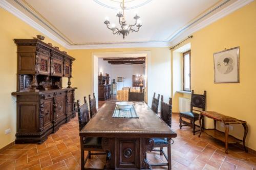 a dining room with a table and a chandelier at La casa in piazza in Panicale
