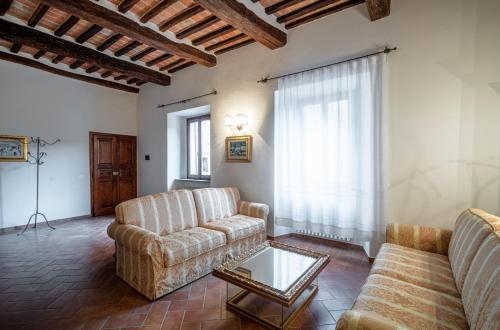 a living room with two couches and a coffee table at La casa in piazza in Panicale