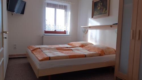 a bed in a room with a window and a television at Holiday Home Benecko 101 in Benecko