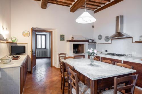 a kitchen with a table and chairs in a room at La casa in piazza in Panicale