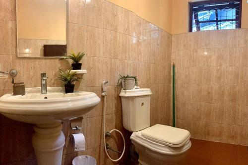 a bathroom with a sink and a toilet and a mirror at Dili's Home Stay in Kandy