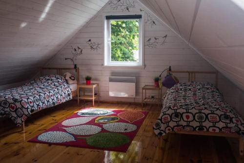 ein Schlafzimmer mit 2 Betten und einem Teppich im Dachgeschoss in der Unterkunft Roztocze, Podlesina; Dom z dużym ogrodem i sauną na szlaku rowerowym in Podlesina
