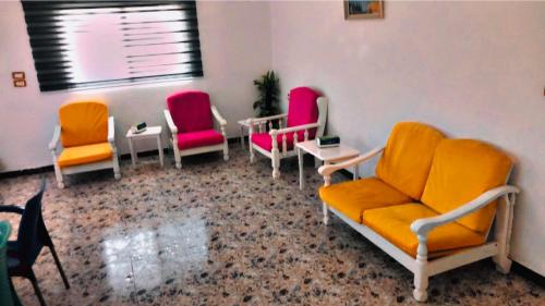 una sala de espera con sillas, mesas y una ventana en Bahaa, en Jerash