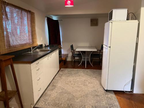 a kitchen with a white refrigerator and a table at Kukumoa Cabin in Opotiki